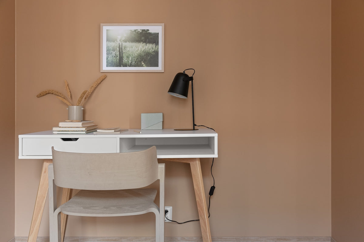 A desk with a chair and a picture on the wall